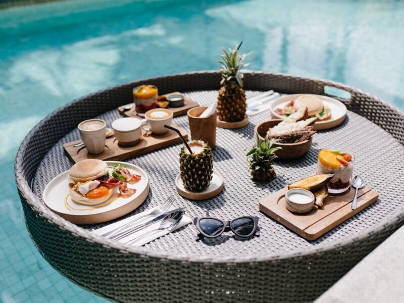 A floating breakfast tray laid out on a pool